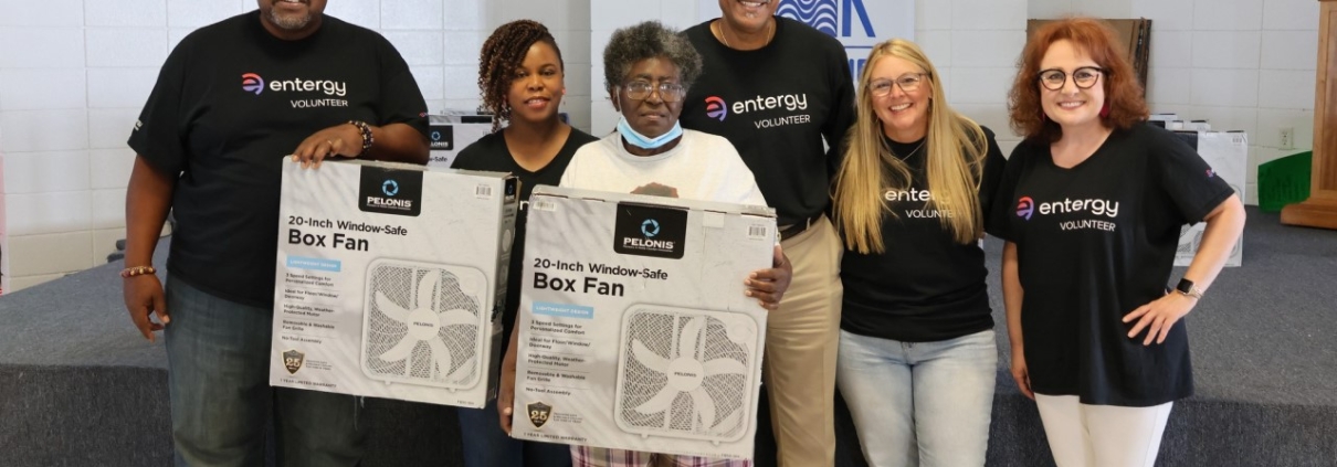 Entergy volunteers at a fan giveaway with a customer.