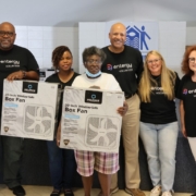 Entergy volunteers at a fan giveaway with a customer.