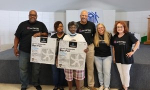 Entergy volunteers at a fan giveaway with a customer.