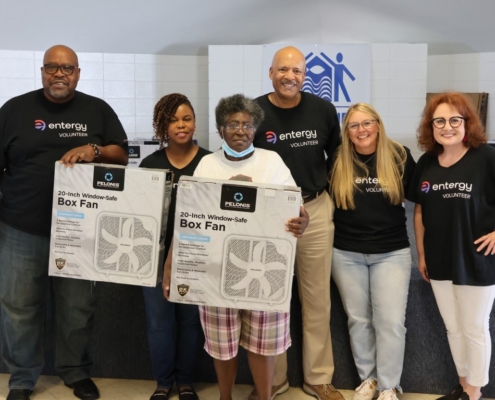 Entergy volunteers at a fan giveaway with a customer.