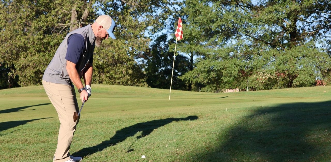Golfer on the putting green at the annual The Power to Care Charity Golf Classic in Arkansas.