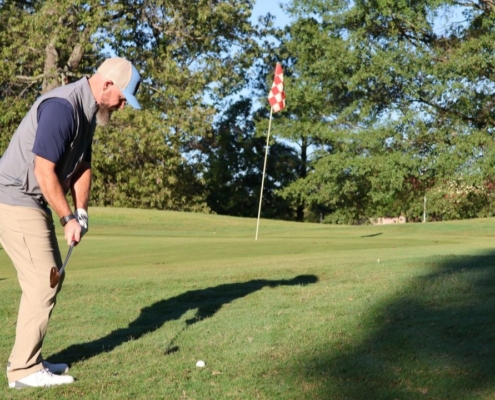 Golfer on the putting green at the annual The Power to Care Charity Golf Classic in Arkansas.