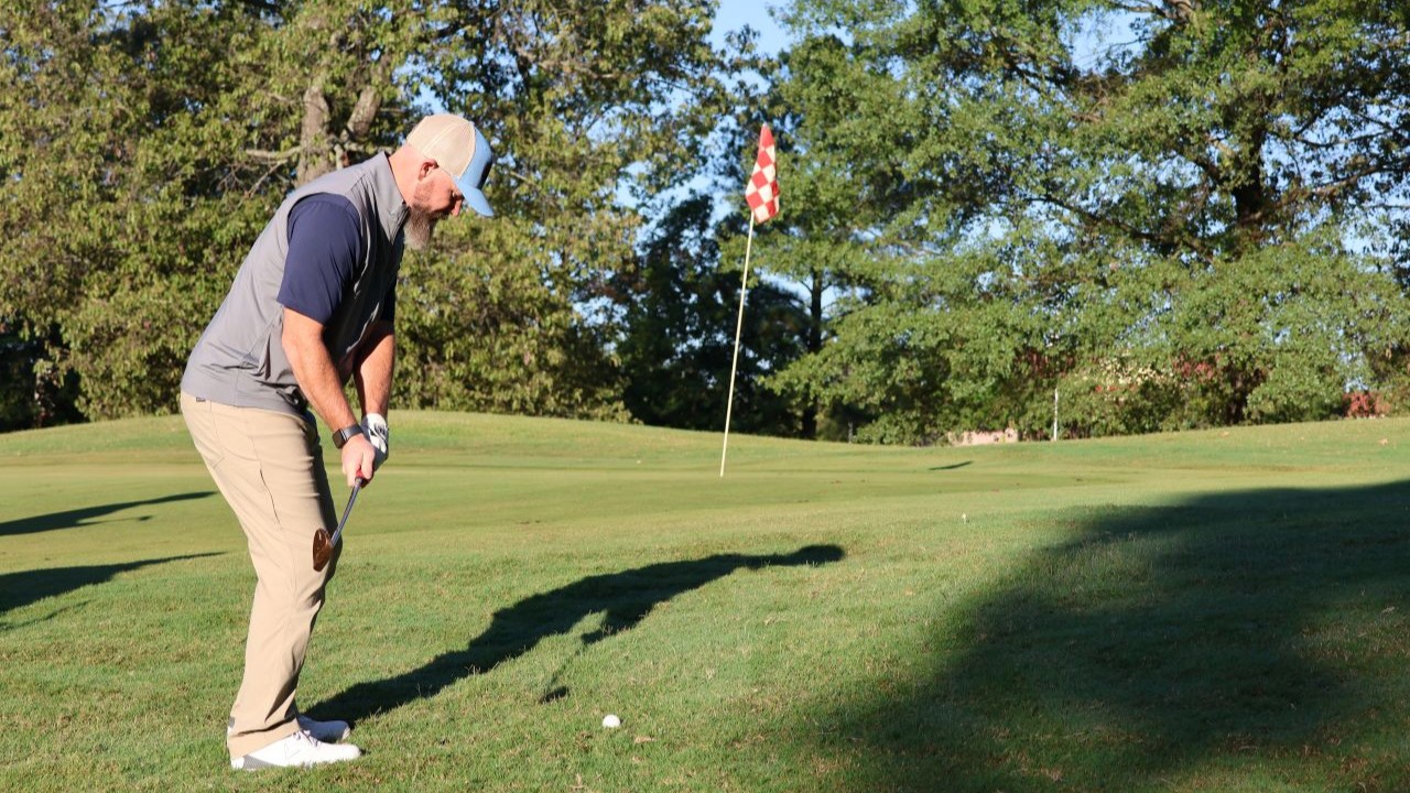 Golfer on the putting green at the annual The Power to Care Charity Golf Classic in Arkansas.