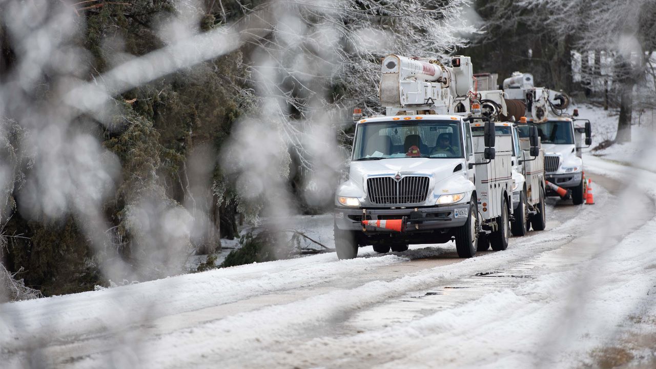 vicksburg-winter-restoration Utility bucket trucks lined up on iced over road in Vicksburg, Mississippi